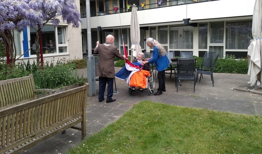 Mevrouw van der Linden (100) en burgemeester Van Bennekom hesen samen de vlag. 