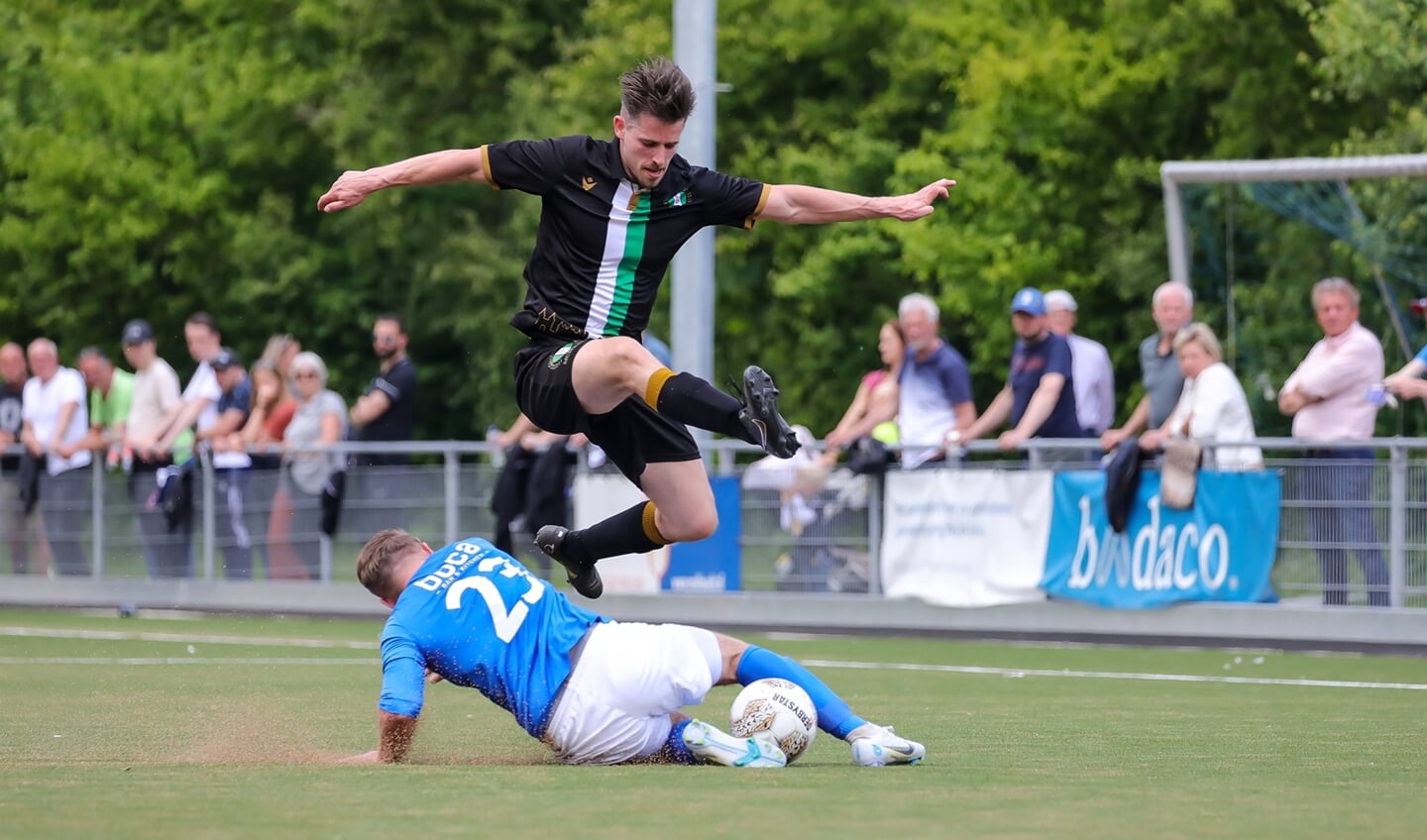 EDO-linksbuiten Bas Janmaat ( zwart shirt en zwarte broek ) ontwijkt een tackle van Tim Bakker. 