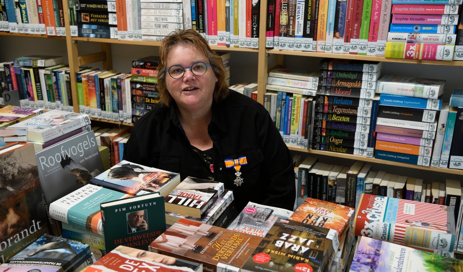 Sandra Mouw tussen de boeken van de bibliotheek in De Wardborg. Hier voelt ze zich als een vis in het water.