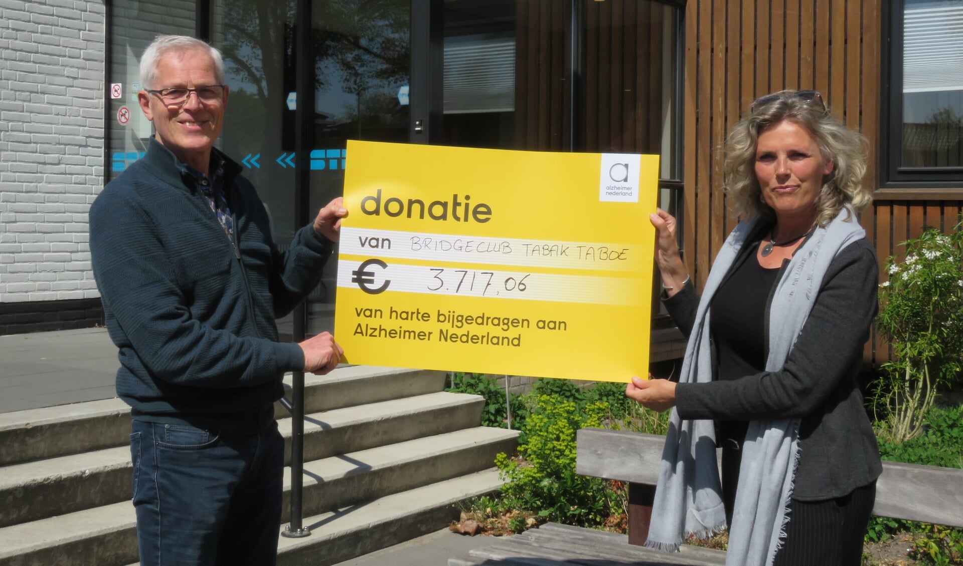 René Ouwerkerk overhandigd cheque aan Anneke Vegter van Alzheimer Nederland. 