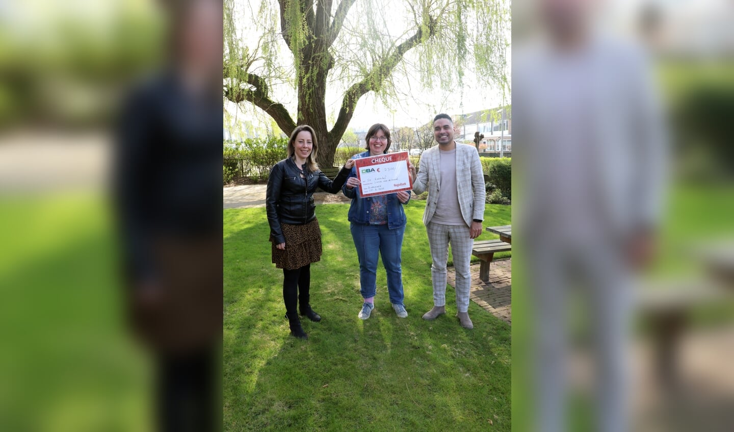 Jolanda en Mitchy van DBA advies reiken de cheque uit aan bewoonster Femke