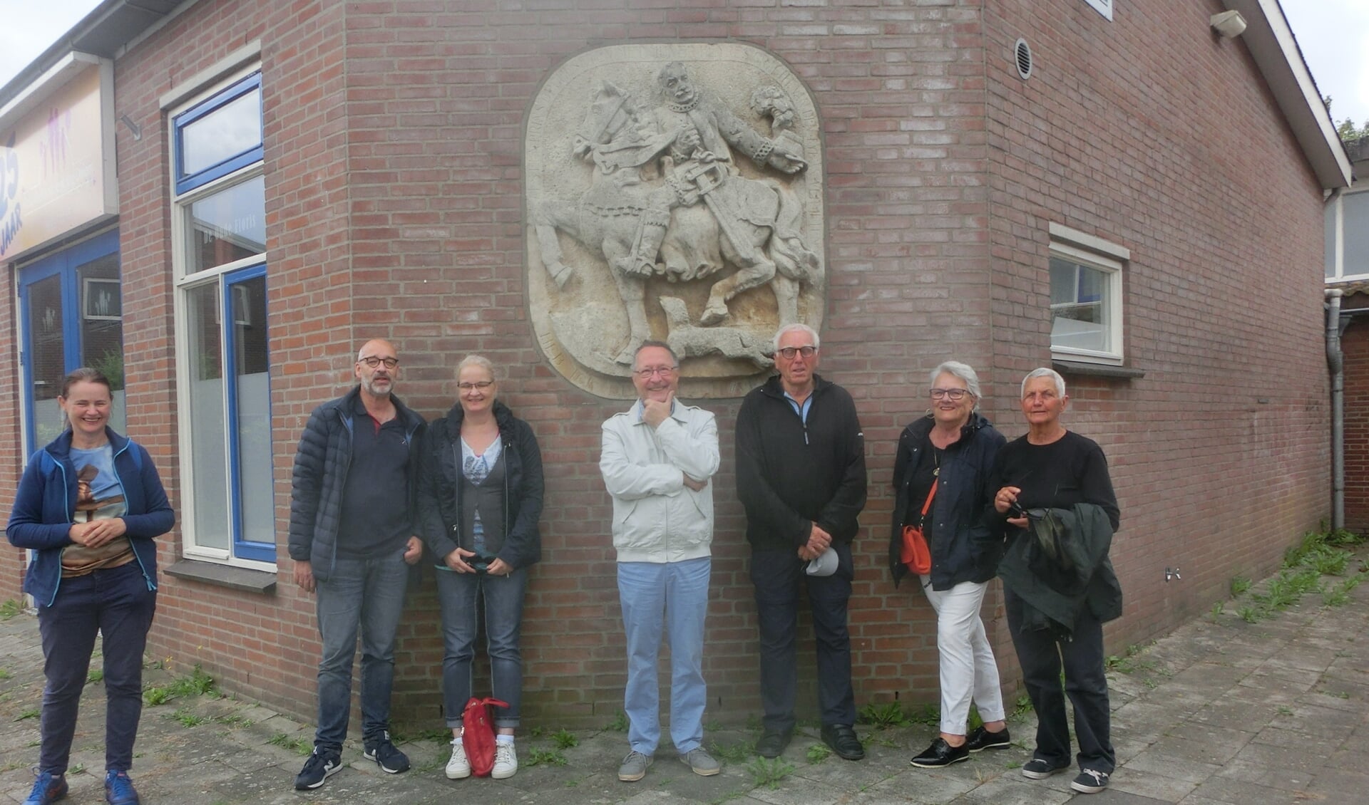 Marleen van Zwienen (links) met wandelaars bij een gevelsteen in Gorinchem