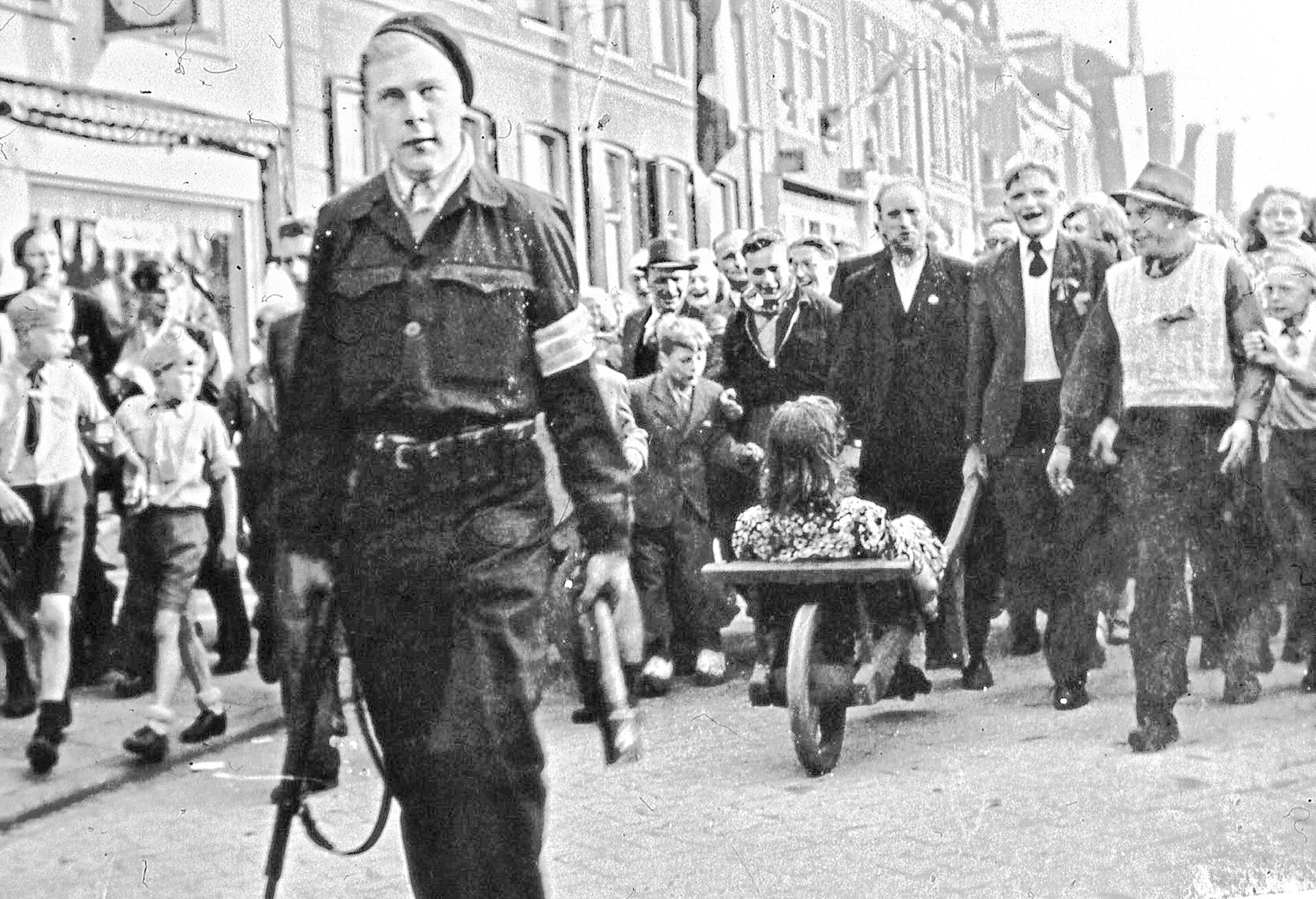 De meest iconische bevrijdingsfoto van WOII in Veenendaal: een vrouw wordt in de Hoofdstraat opgebracht.
