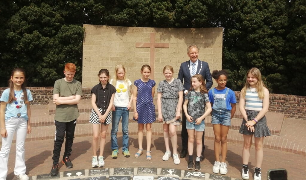 De vredestegels zijn bij het monument geplaatst. Links kinderburgemeester Feline, 4e van rechts: Babette Krabbe.