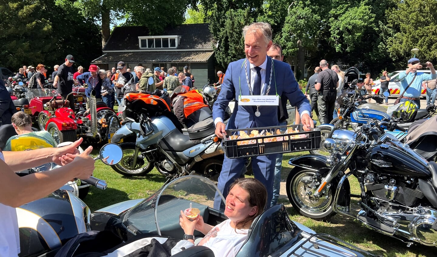 Burgemeester Mark Röell deelt ijsjes uit aan de deelnemers van de motorrun.