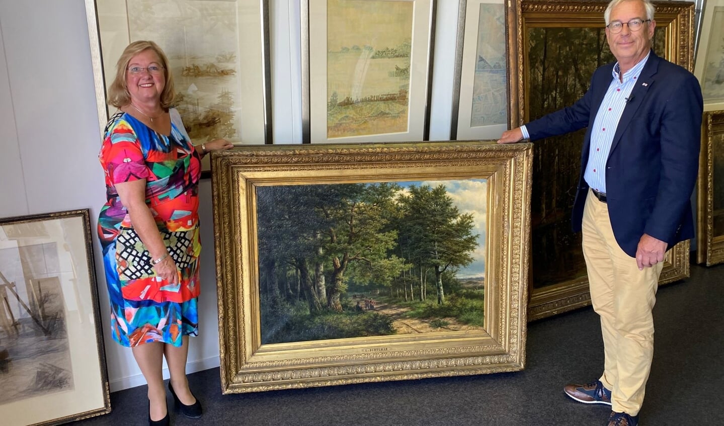 Leonie Rolink en Paul Tirion tonen een werk van C. Schulman, dat een landschap bij de Westerbouwing weergeeft.