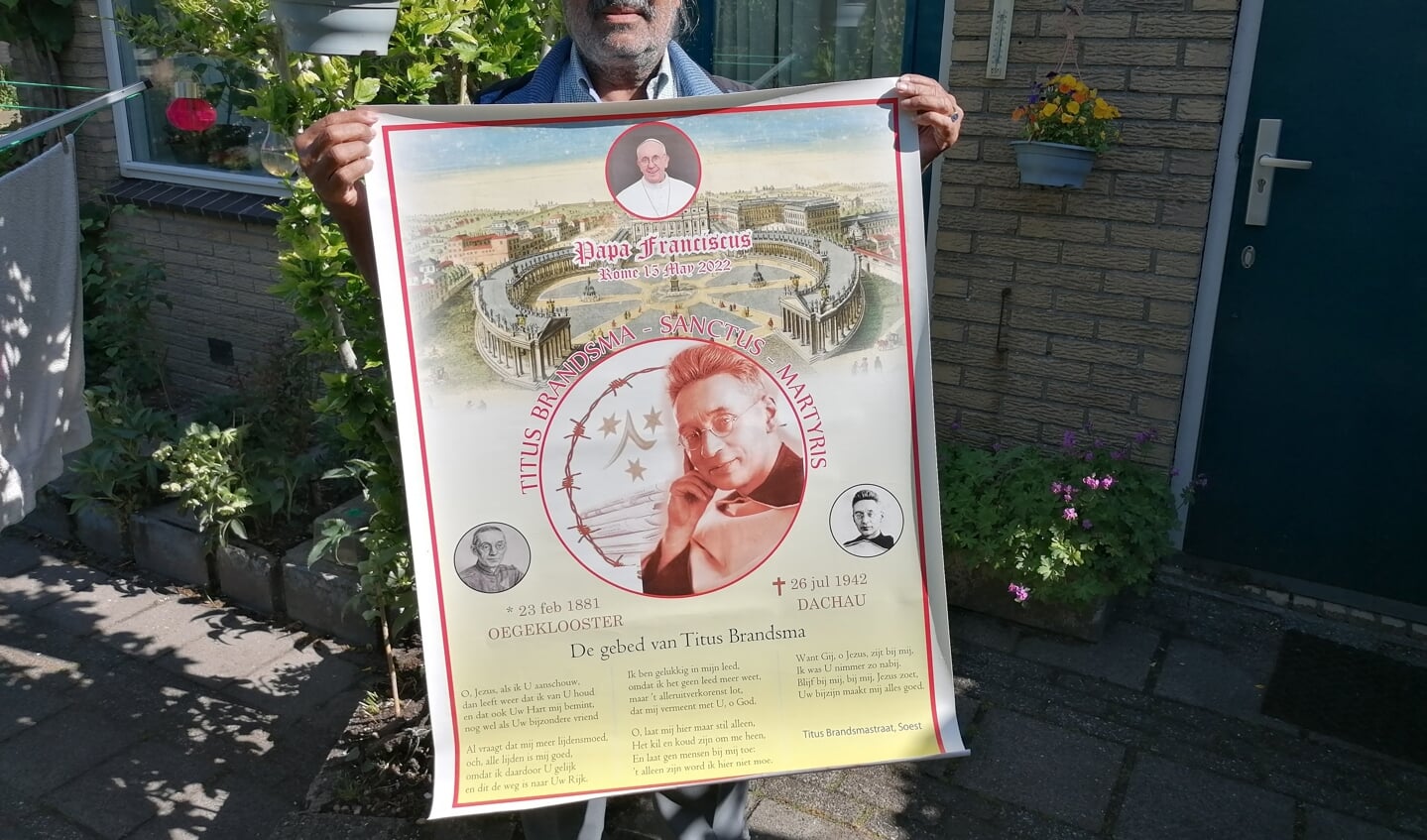 Luke Varikat met de door hem ontworpen poster ter ere van de heilige Titus Brandsma.