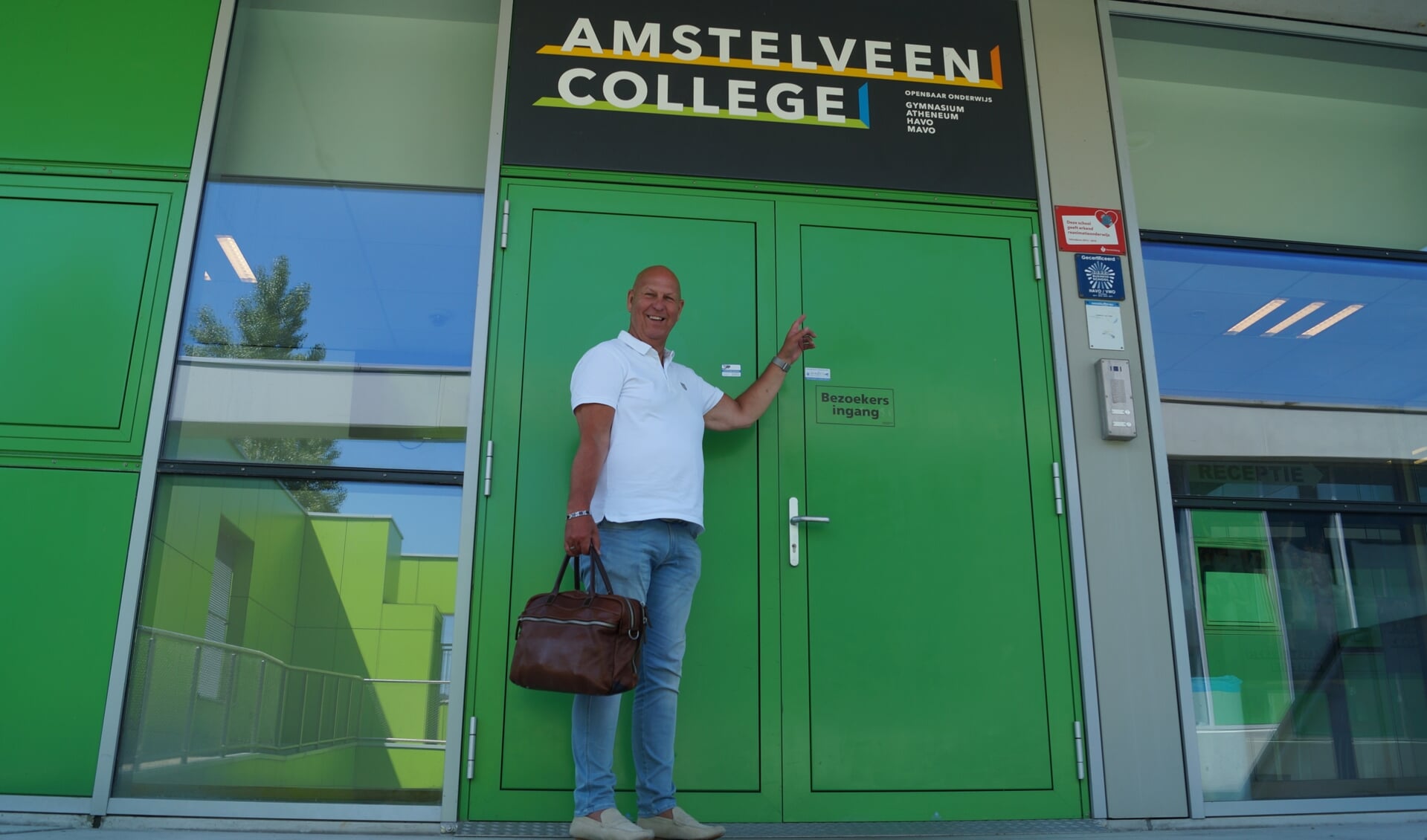 Kees Langelaar bij de ingang van het Amstelveens College.