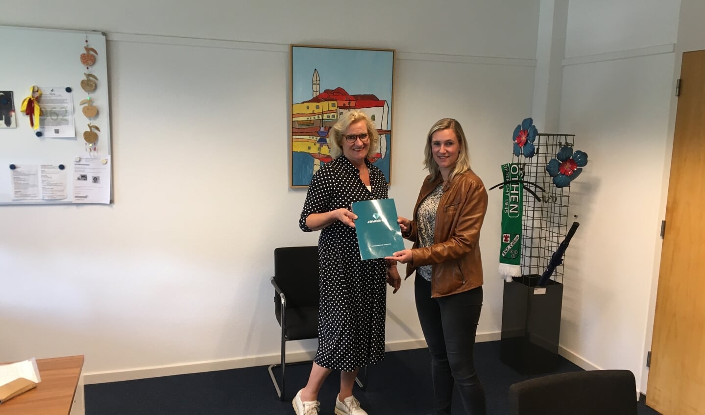 Monique Verloop overhandigt het sociaal jaarverslag aan wethouder Wil Kosterman