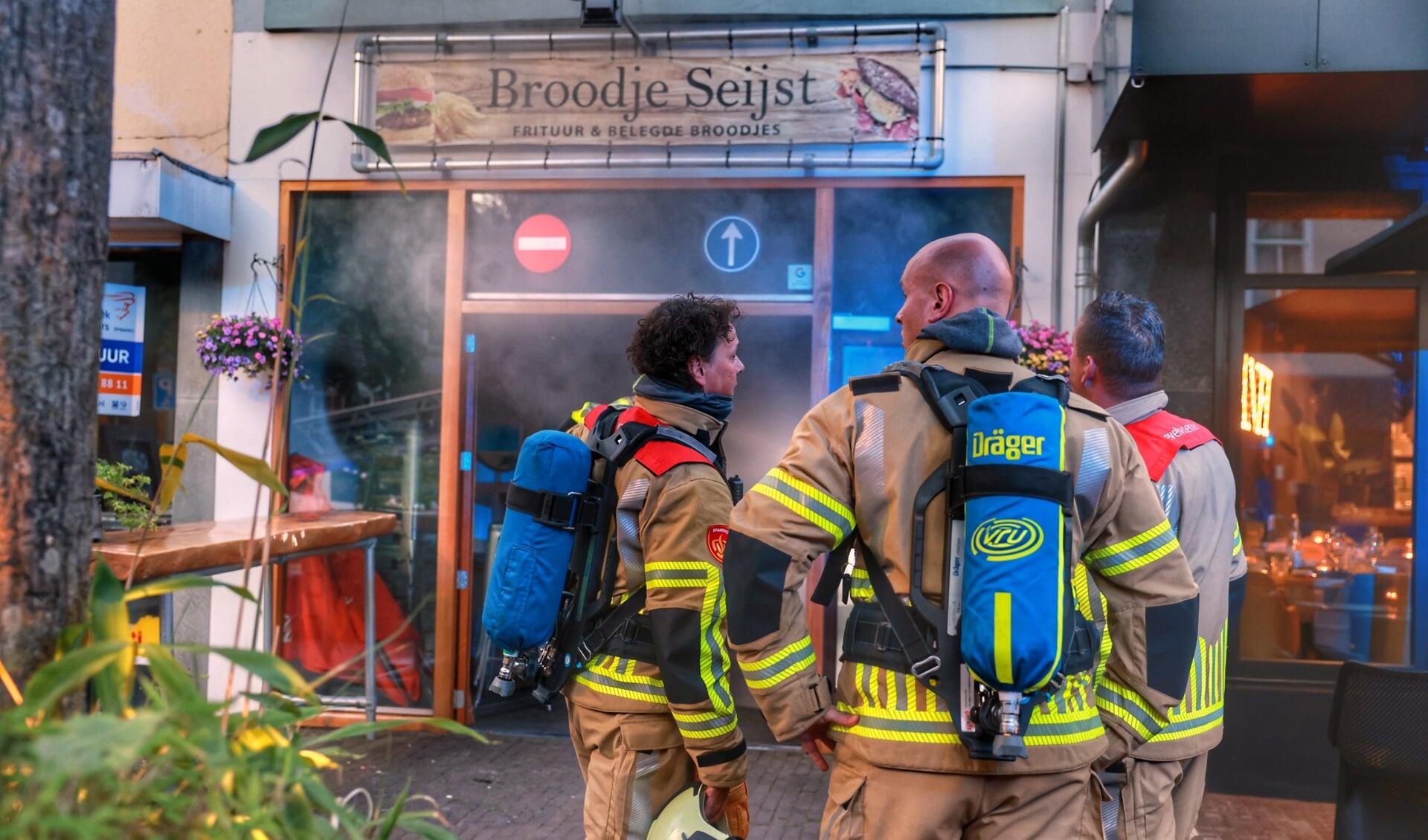 Met perslucht gaat de brandweer de zaak binnen.