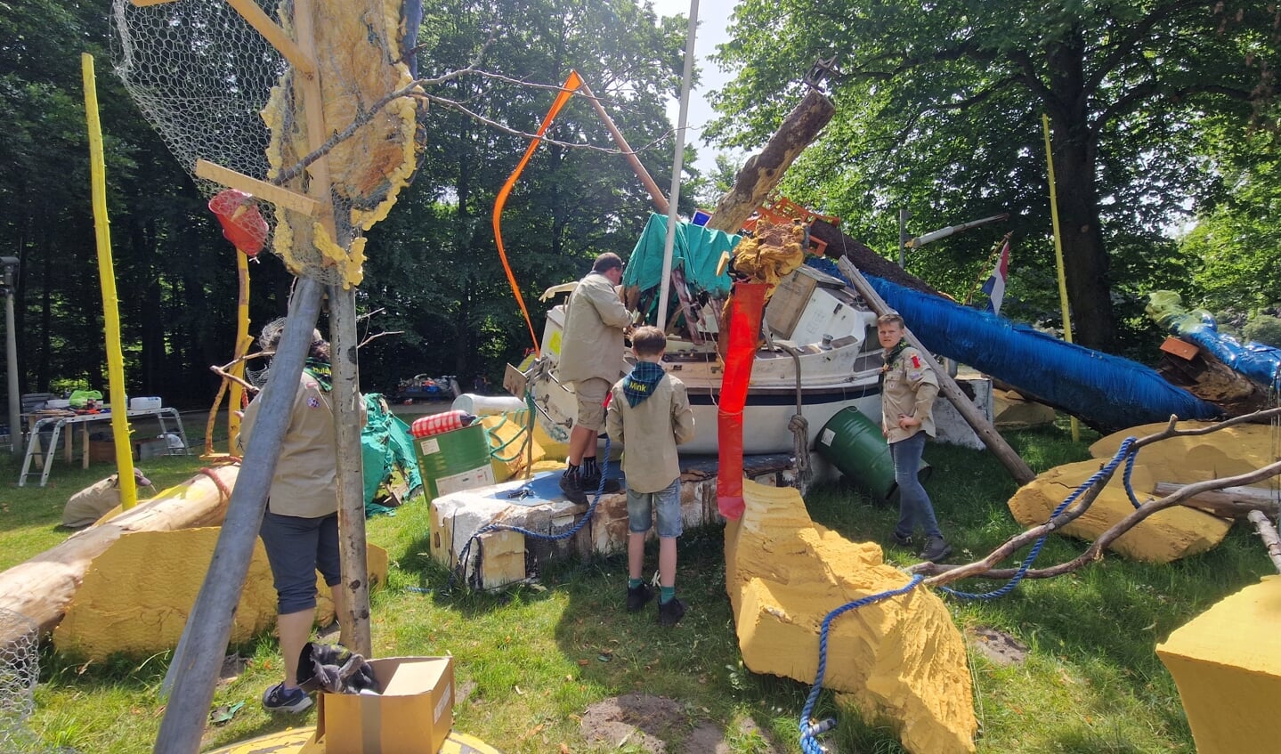 Merhula Scouts voegen hun afgebrande tent en vlag toe aan kunstschip van kunstenaar David Bade.