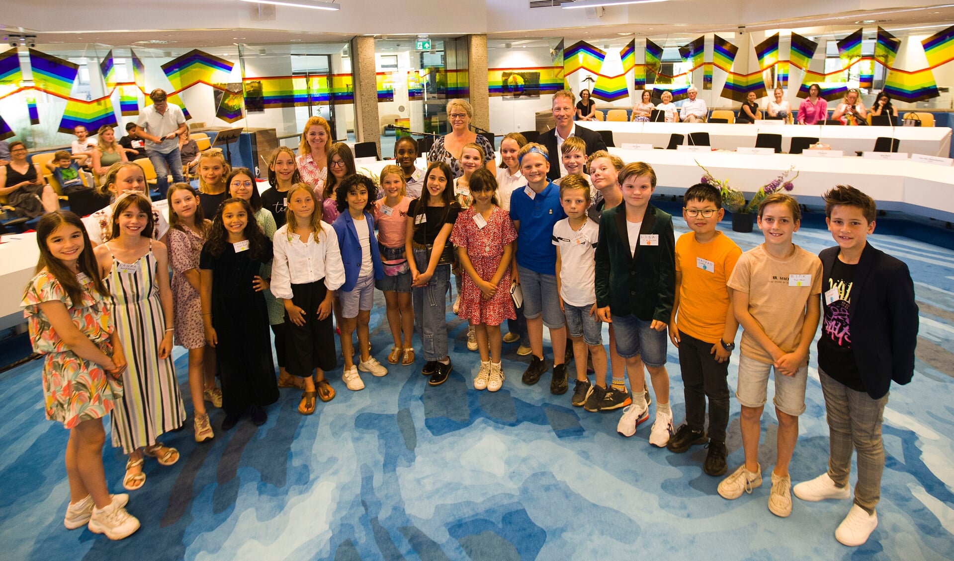 De nieuwe kinderraad met kinderburgemeester Lode in het midden (met een blauw shirt en een blauwe hoofdband in zijn haar).