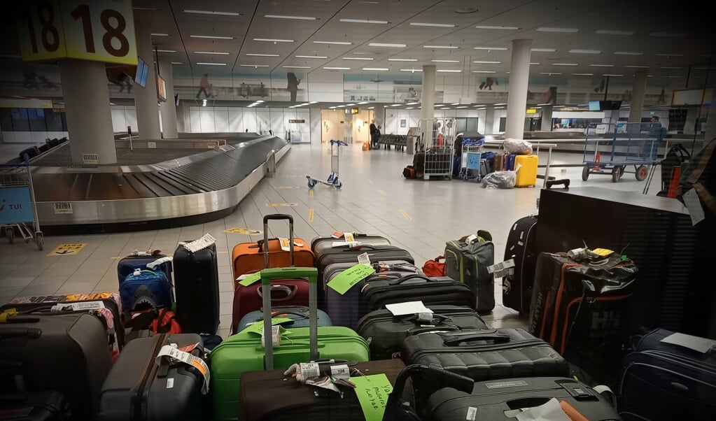 Tientallen koffers zijn bij de bagagebanden bij elkaar gezet. 