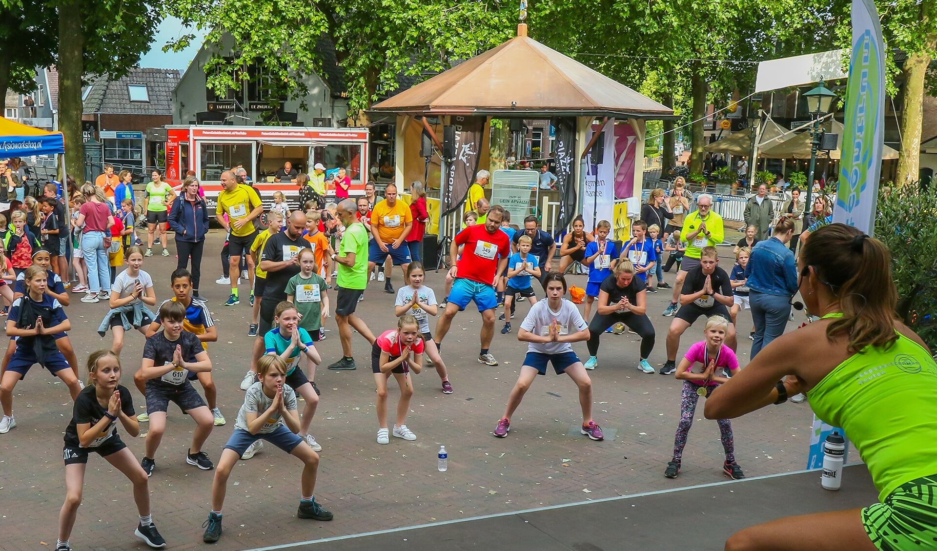 Deelnemers aan de zestiende Loop door Houten bij de warming-up.