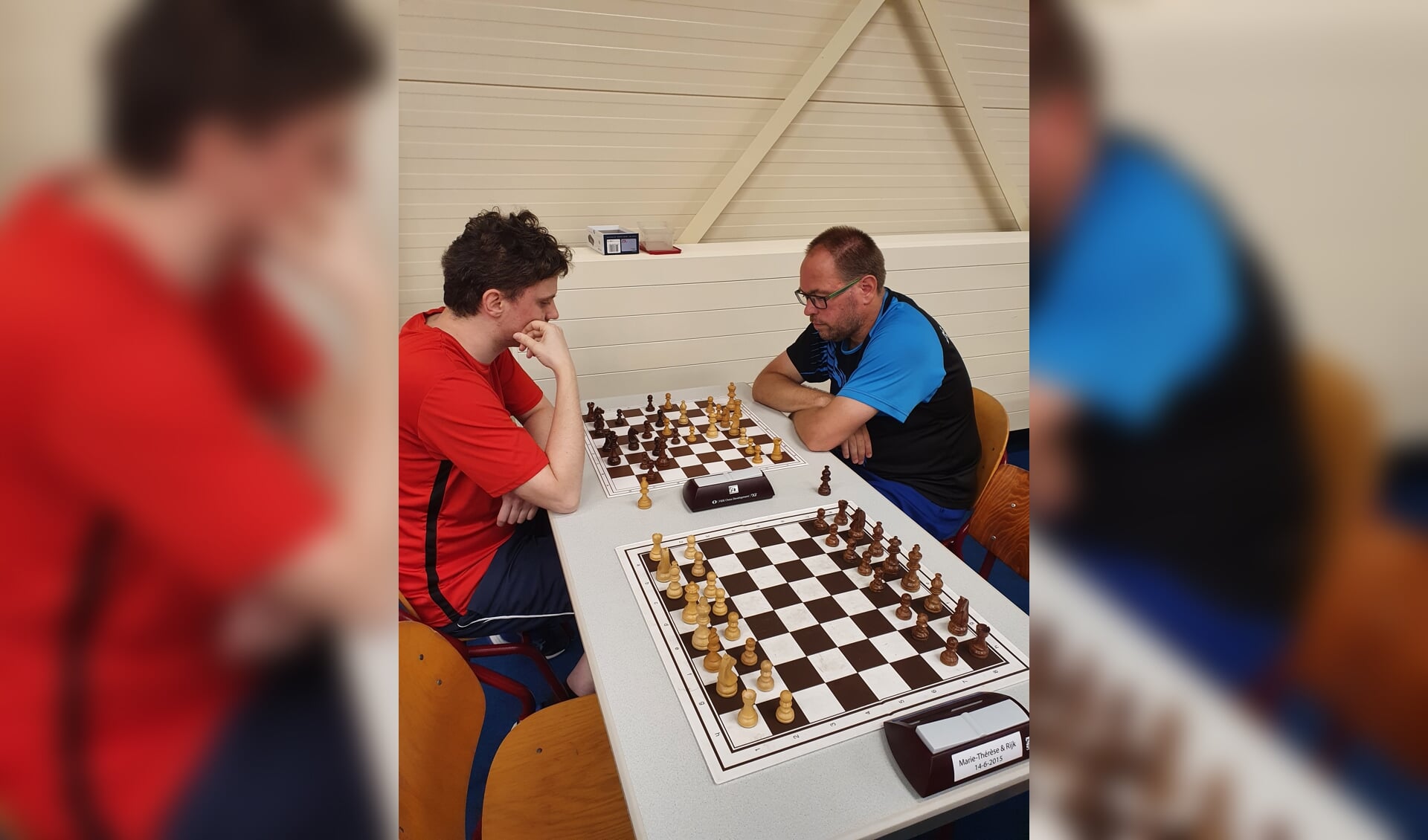 Toernooiwinnaar Bram van den Berg (rechts in het blauw) speelt in de zesde rond zijn schaakpartij tegen Sytse Koopmans.