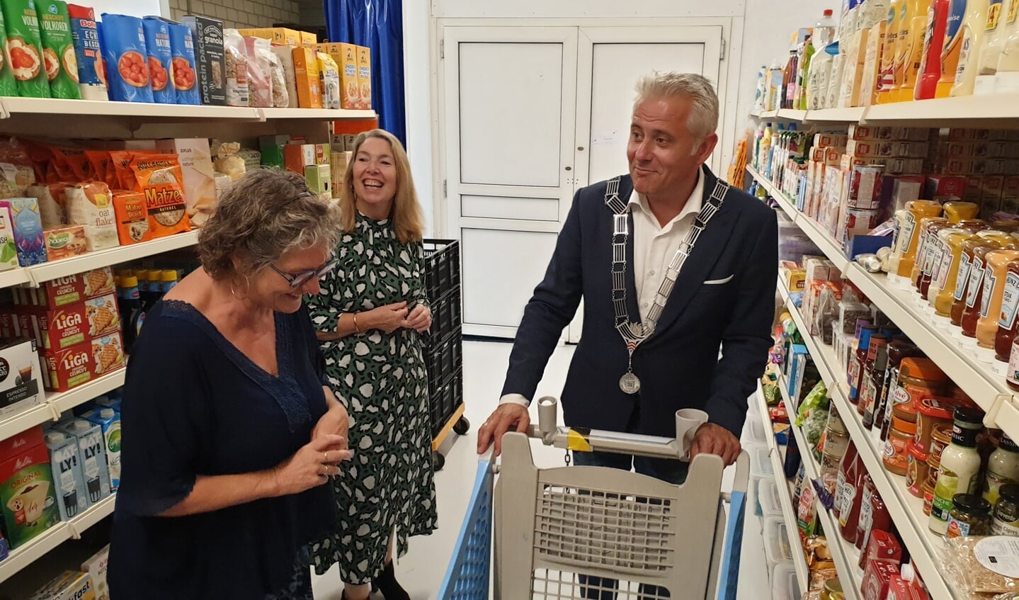 Wethouder Hagedoorn in de winkel, met een vrijwilligster en op de achtergrond voorzitter Jolanda van Hulst-Mazirel. 