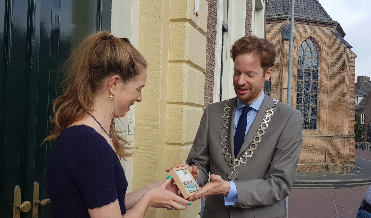 Marga van Oers overhandigt de eerste Wageningse StoryTile aan burgemeester Floor Vermeulen.