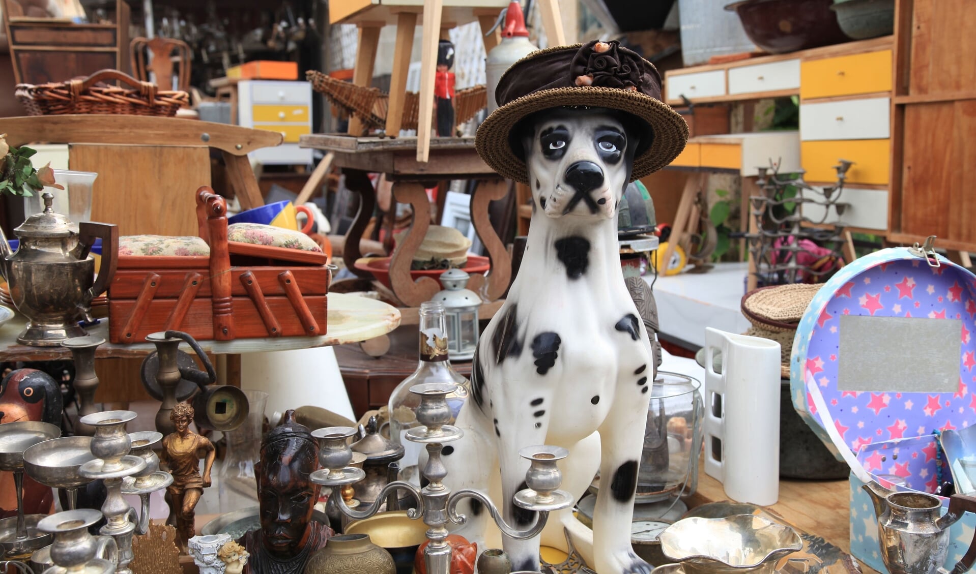 55941519 - old vintage objects and furniture for sale at a flea market. toy vintage dog. selective focus