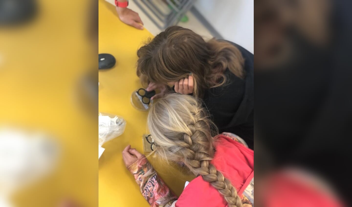 Leerlingen van de Regenboogschool bestuderen een teek met een vergrootglas