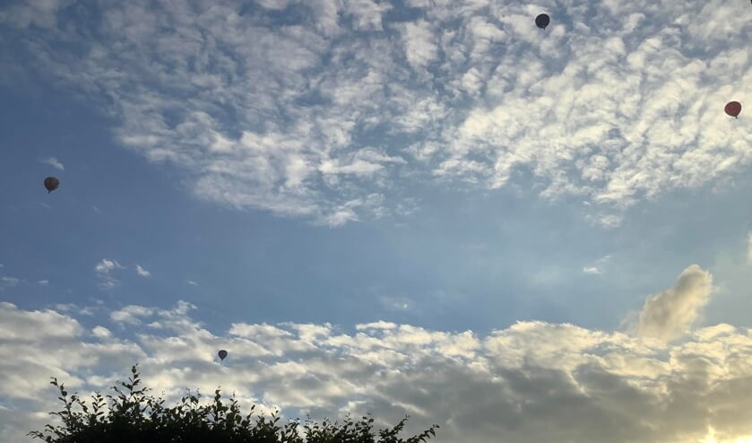 ,,Meerdere luchtballonnen passeerden met een prachtig wolkendek als achtergrond."