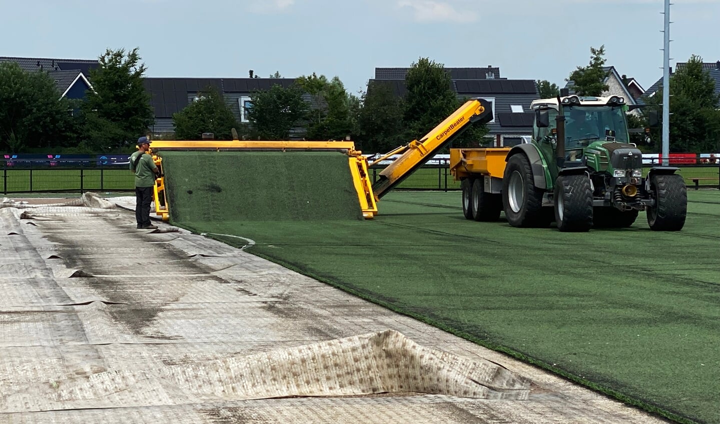 De oude laag kunstgras maakt plaats voor een nieuwe.