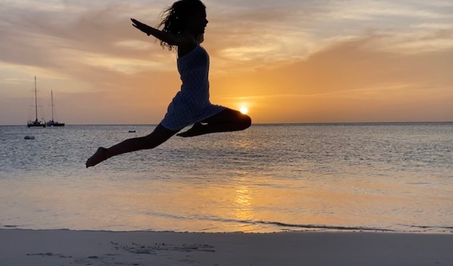 'Een mooie zonsondergang op Aruba. Hier maak ik een sprong met de zon nog net boven mijn knie. Mijn moeder heeft de foto gemaakt.'
