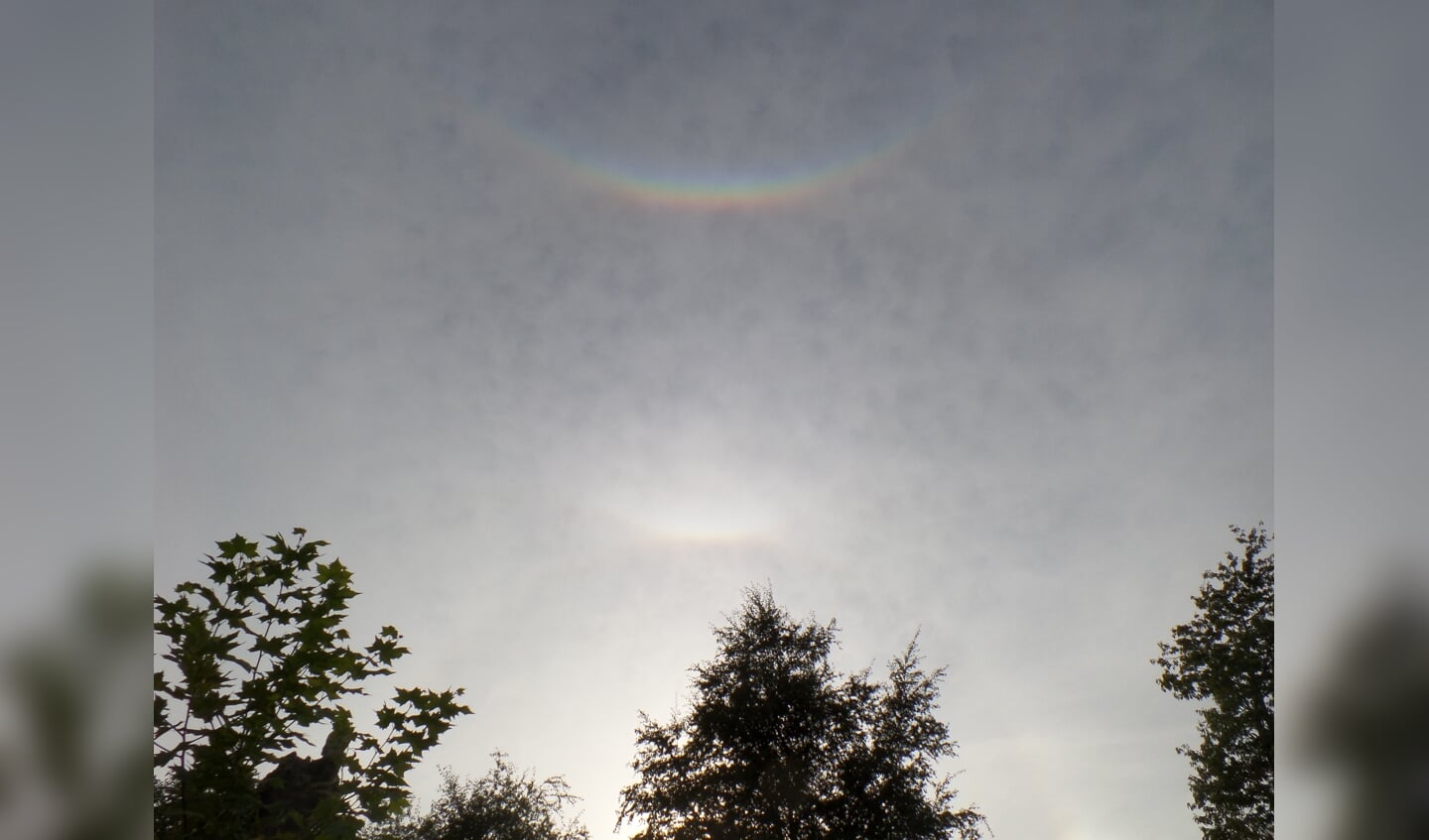 'Een omgekeerde (dubbele) regenboog gefotografeerd op 30 augustus om 18.20 uur in onze tuin in Stoutenburg. Het natuurverschijnsel wordt circumzenitale boog genoemd en ontstaat hoog in de lucht in dunne bewolking in combinatie met een bepaalde stand van de zon. Ik had het nog nooit eerder gezien.'