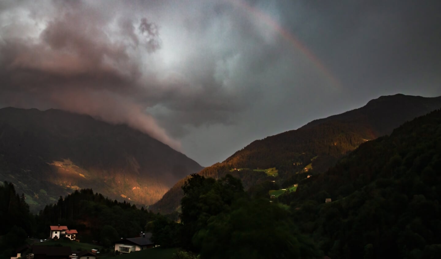 'Tijdens een zware onweersbui in de Oostenrijkse Alpen prikt de zon net nog even een gaatje in het wolkendek.'