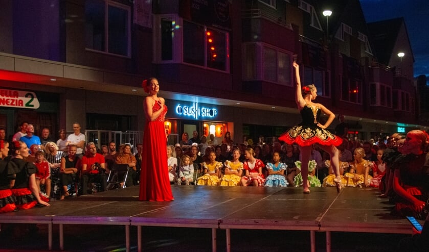 Een van de danseressen van het showballet in rode Spaanse tutu op spitzen samen met Donij van Doorn te midden van het publiek.