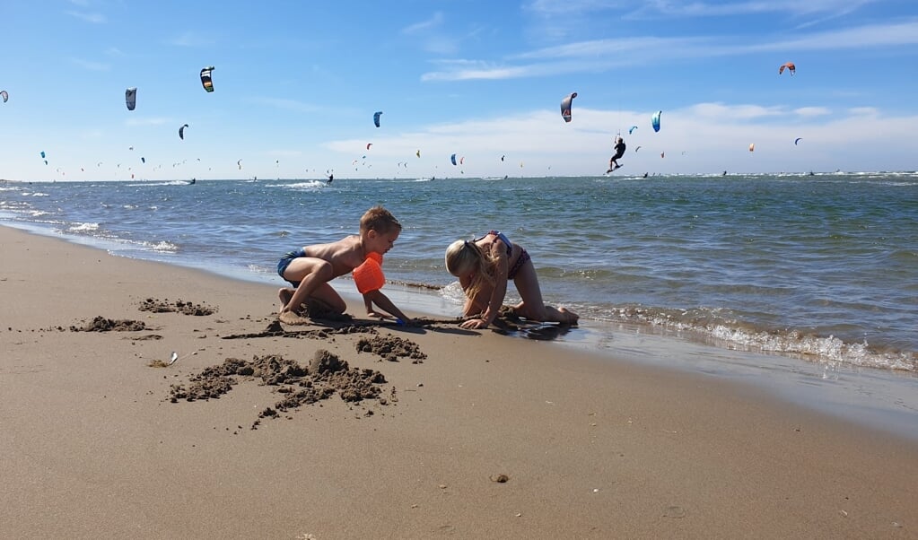 Zon en wind in Ouddorp: een perfecte combinatie. Lieke en Milan konden zwemmen en spelen op het strand, terwijl papa lekker kon kitesurfen.
