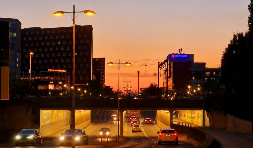 ,,Deze foto is gemaakt op zaterdag 13 augustus 2022, toen ik richting huis liep na een prachtig bruiloftsfeest. De zonsondergang, gecombineerd met de al ontstoken verlichting grepen mij. Al is de locatie (spoorbrug voor rotonde Eemplein) meestal niet echt een 'plaatje', dit beeld zou niet misstaan in een film.