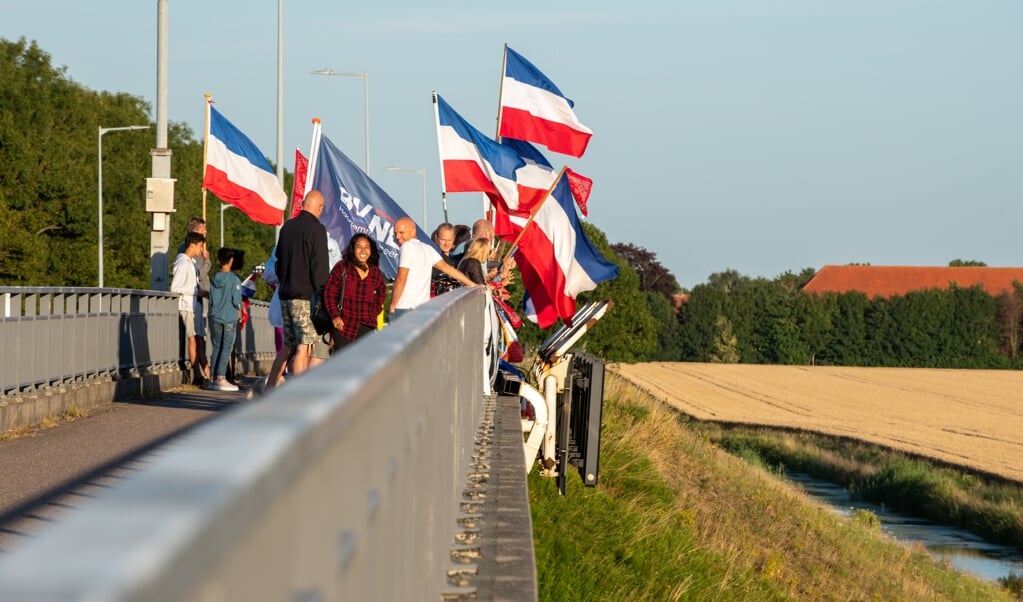 Al weken staat een groep van zo’n dertig à veertig mensen zes dagen per week op het viaduct over de A4 bij Burgerveen te vlaggen.