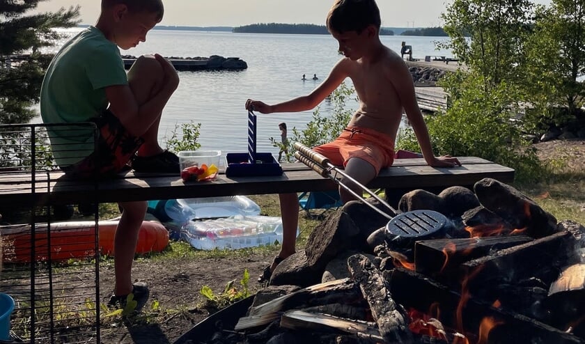 Op de foto ziet u een heerlijk plaatje van het kamperen op zijn Zweeds. Terwijl er op de voorgrond een hamburger gebakken wordt op het kampvuur, spelen onze jongens, Freek en Koen een spelletje vier op een rij….natuurlijk bij een prachtig meer. De foto is genomen op camping Tiveden nabij Tived in Zweden.
