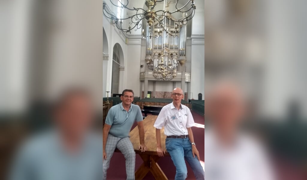 Jan van den Bergh en Arjan Versluis met op de achtergrond het orgel van de Grote kerk