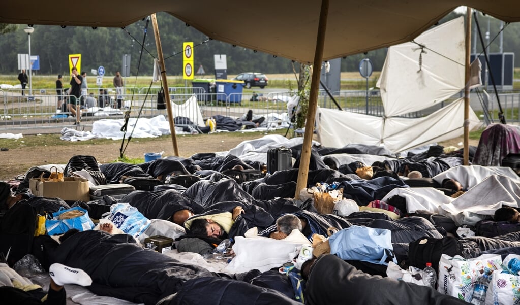 Asielzoekers slapen bij het aanmeldcentrum in Ter Apel.