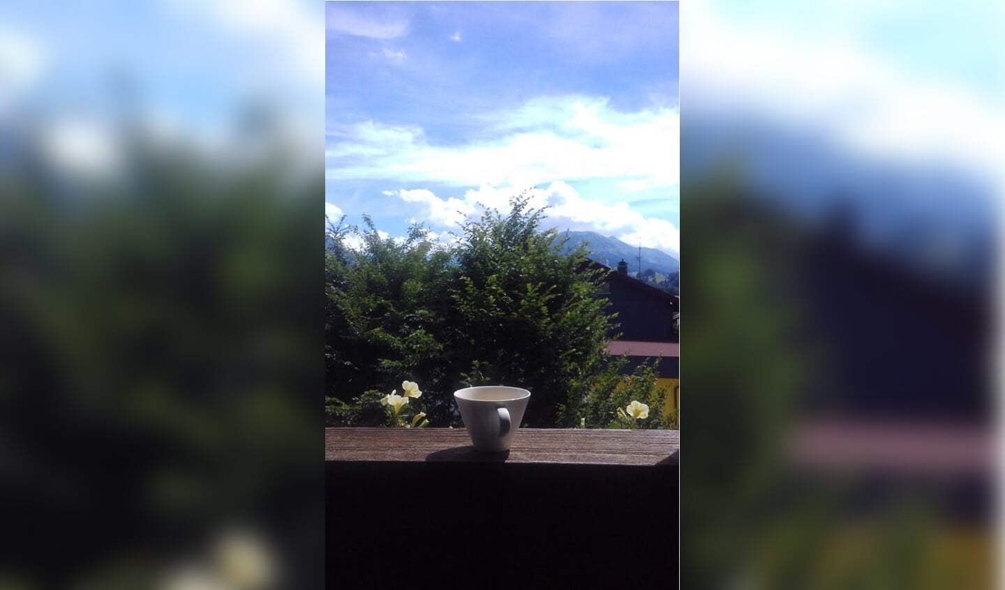 ,,Een kopje thee op het balkon van een typisch Duits hotelletje met bloembakken in de Alpen in Duitsland. Met op de achtergrond de bergen.