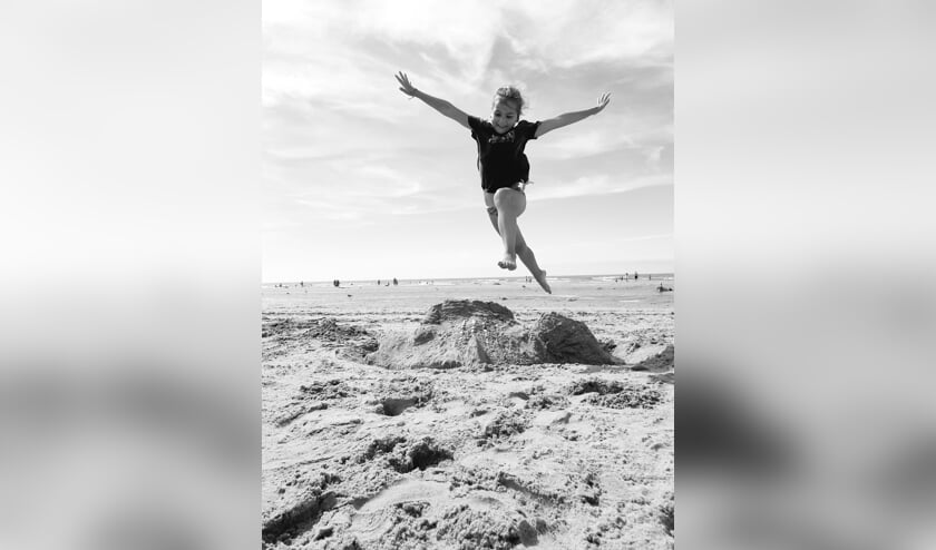 ,,Op de foto staat Jasmijn van Ramshorst, 7 jaar. Springend over haar gemaakte vis van zand op het zonnige strand van Zandvoort.
