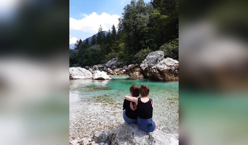 De foto is gemaakt op 25 juli. Onze dochters zijn zichtbaar aan het genieten van het prachtige blauwe water van de Soca rivier in Slovenië.