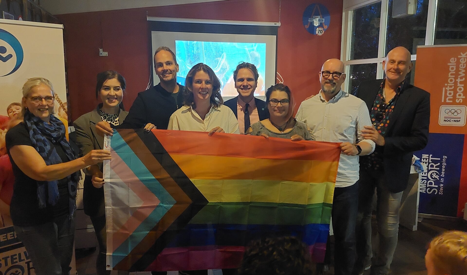 Vertegenwoordigers van de vijf pilot-verengingen poseren met de regenboogvlag uit de All Together Challenge Box