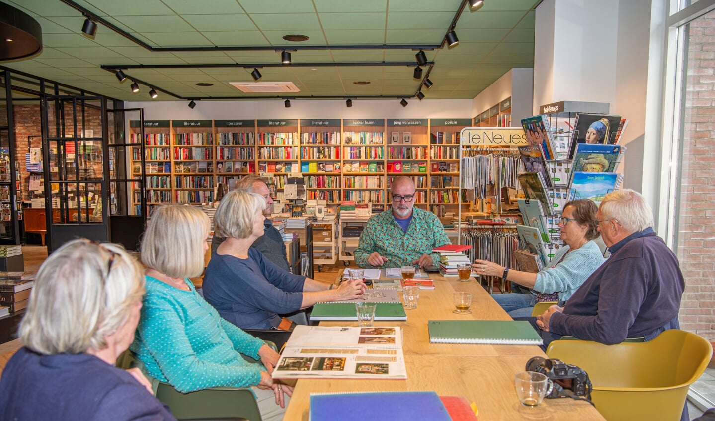 Arno Koek (midden) vertelt belangstellenden over de historie van zijn boekhandel.