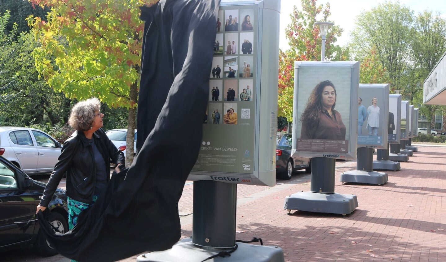 Wethouder sociale zaken, Jacqueline de Maa onthult een van de borden van de expositie.