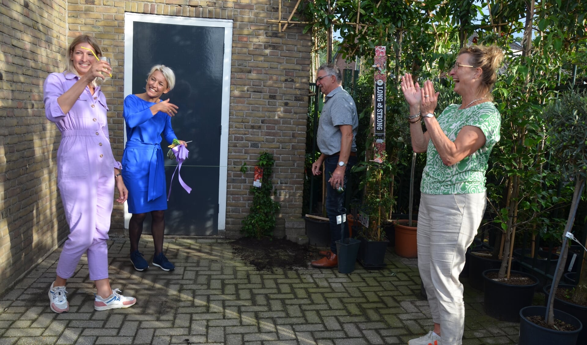 Corienne Merkens, burgemeester Iris Meerts en de ouders van Corienne proosten op de groenetoren