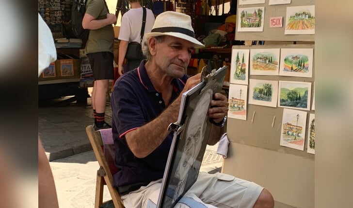 Deze foto is 27 juli 2022 in Florence, Italië genomen. Op deze foto is een straatartiest te zien die druk bezig is met een tekening. Ik vind deze foto bijzonder, want je kunt goed zien dat deze man vol passie en plezier met de tekening bezig is.