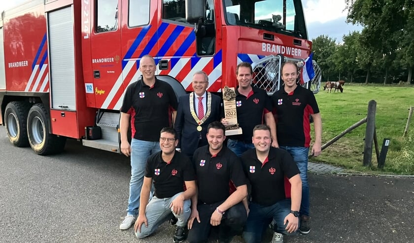 De winnende ploeg van brandweer Harskamp met burgemeester Jan Luteijn.