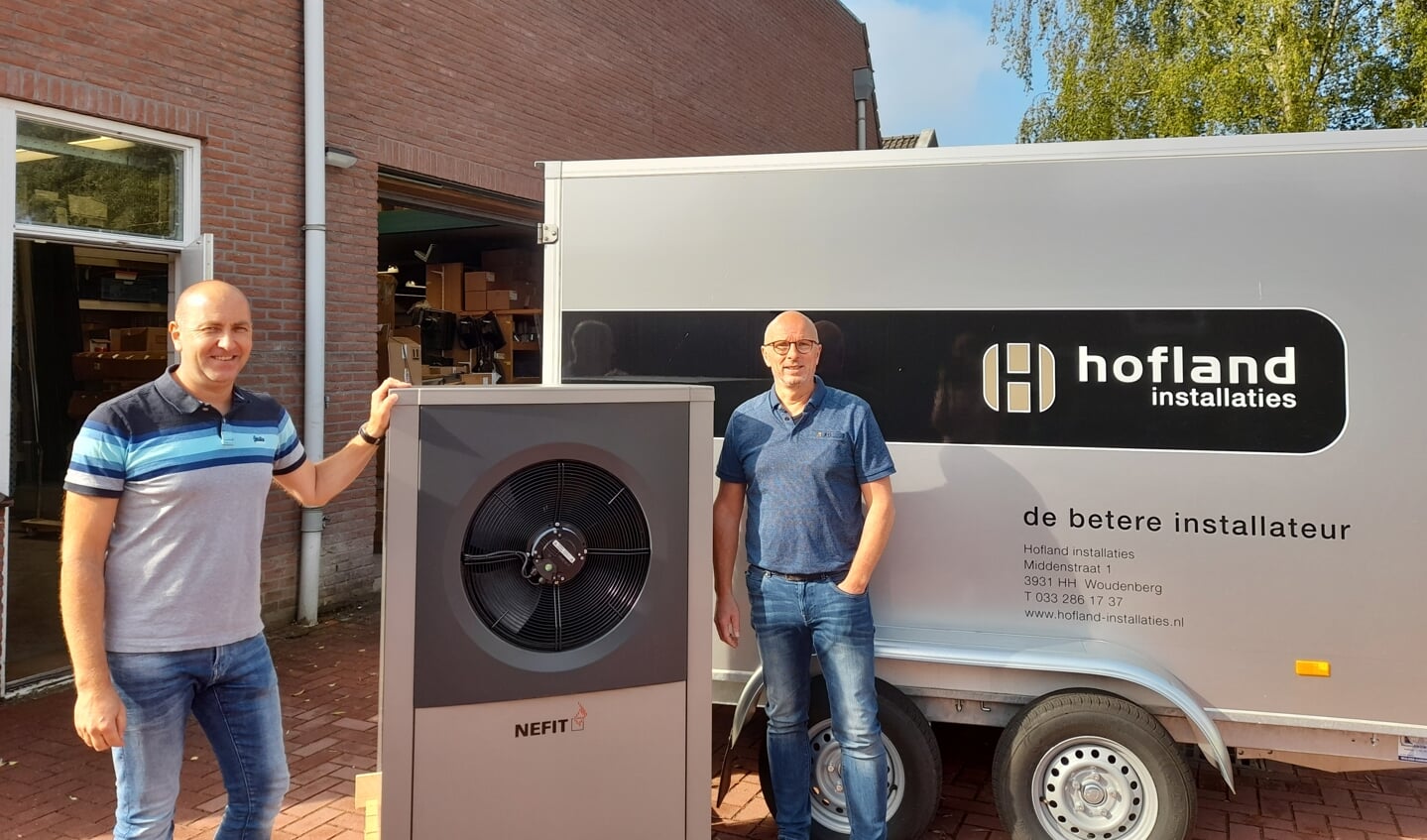 Links Michel Brouwer en rechts Jan Hofland. In het midden een warmtepomp.