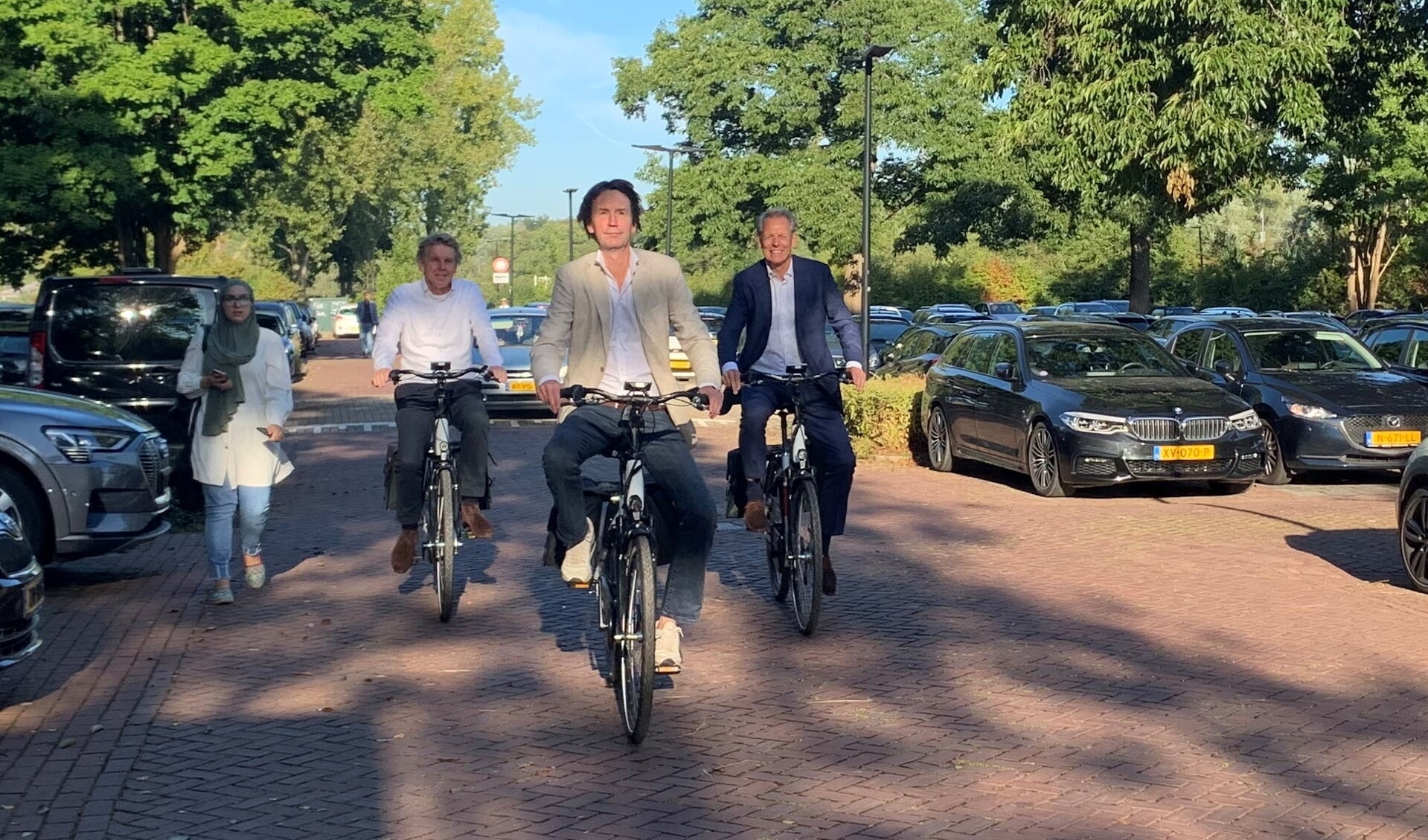 Wethouder Herbert Raat en gemeentesecretaris Bert Winthorst nemen de elektrische fietsen in gebruik.