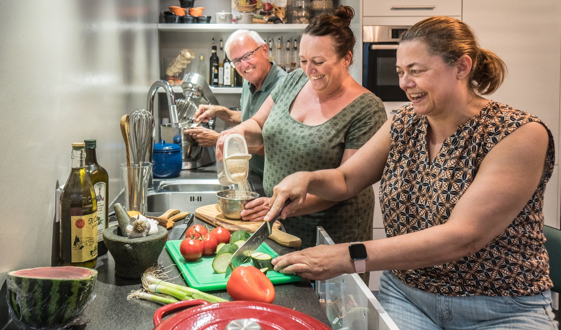 Vrolijkheid in de keuken bij de kokende bewoners vlnr: Jan, Cynthia en Diana.