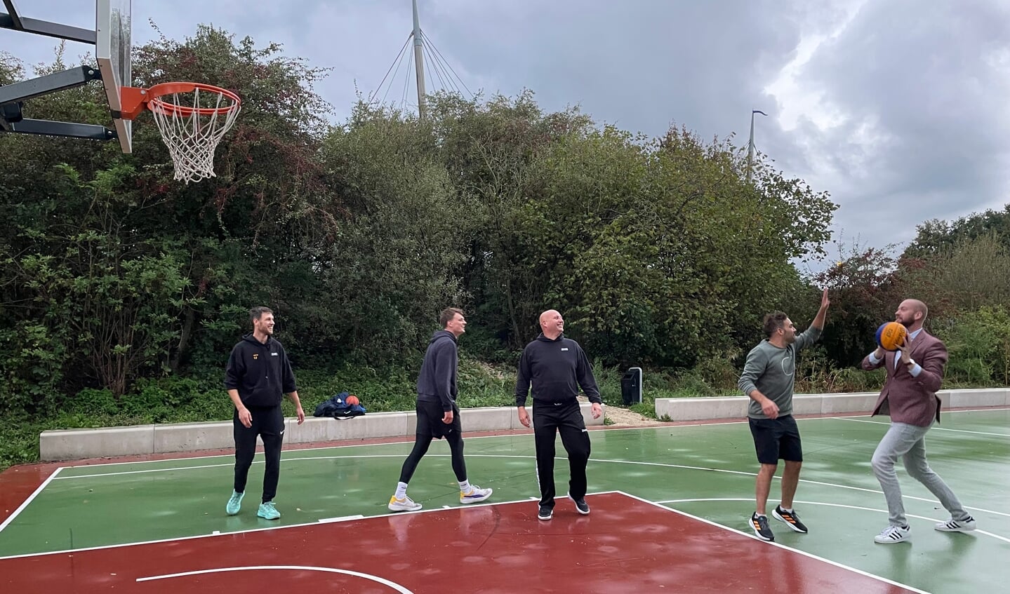 Wethouder Martijn Pijnenburg opent het basketbalveldje aan de Drielandendreef met Jeroen Ooms, Jan Willem Bruggemann, Marc van Stijn en Mark Yntema. (foto: Marco Jansen)