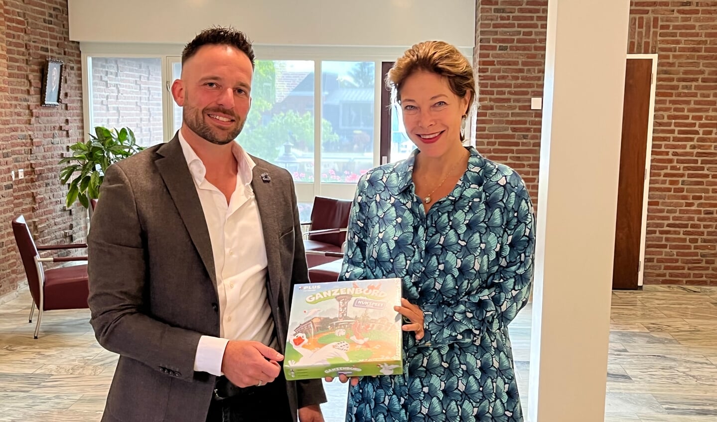 Gabri van Elswijk biedt burgemeester Céline Blom het eerste exemplaar aan van het spel. 