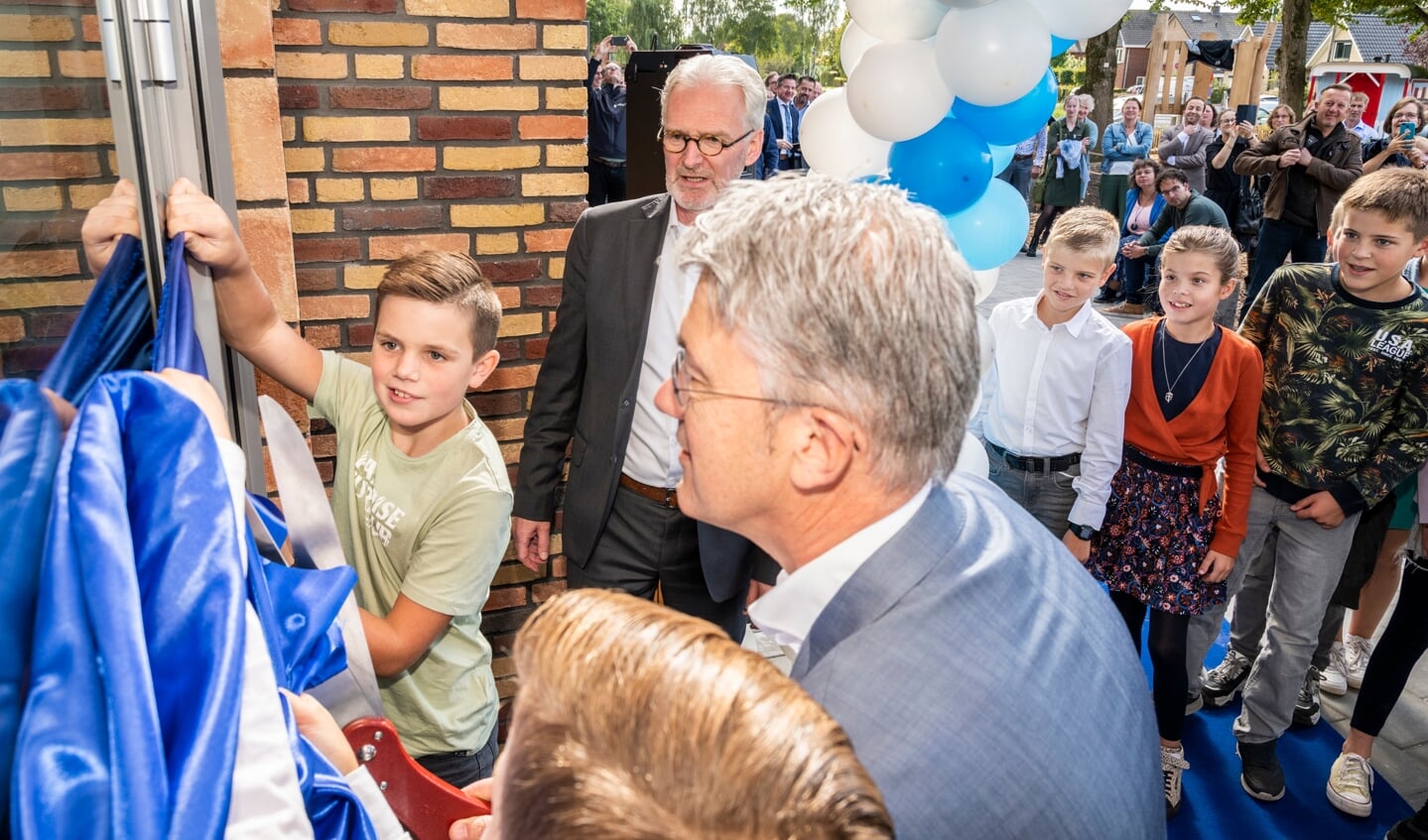Wethouder Leon Meijer en leerlingen van groep acht openen de nieuwe Ruitenbeekschool. Directeur Leen van Dijk kijkt toe.
